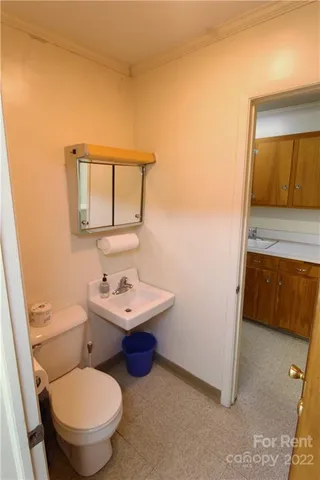 a bathroom with a toilet a sink and mirror