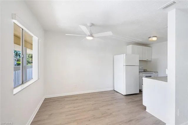 a view of a kitchen with a sink and a refrigerator