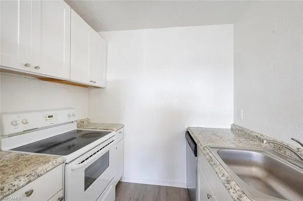 a kitchen with granite countertop a sink and a stove