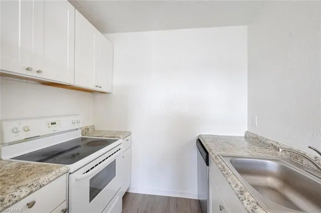 a kitchen with granite countertop a sink and a stove