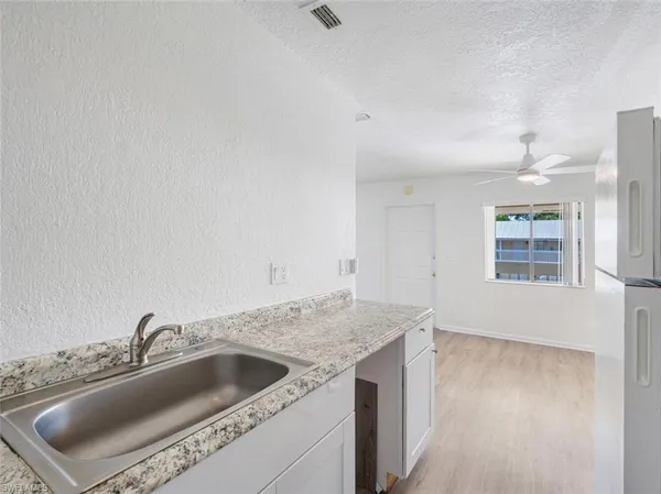 a view with a sink and dishwasher with wooden floor