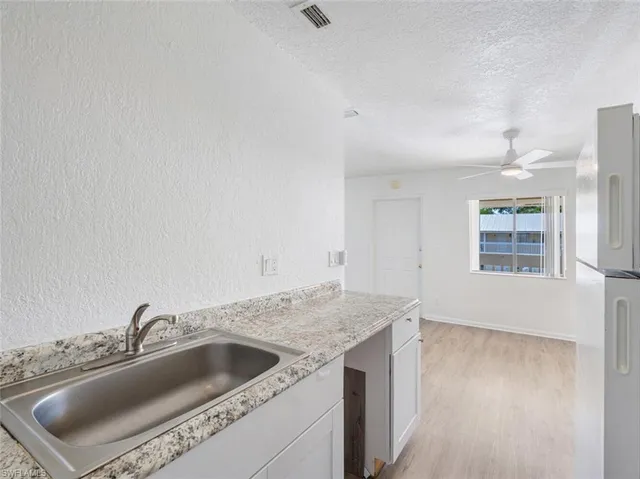 a view with a sink and dishwasher with wooden floor