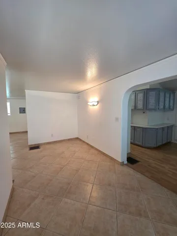 a view of an empty room with wooden floor and cabinet