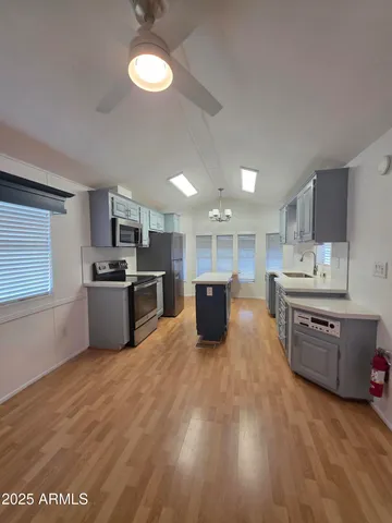 a large kitchen with a stove top oven a sink a counter space and cabinets