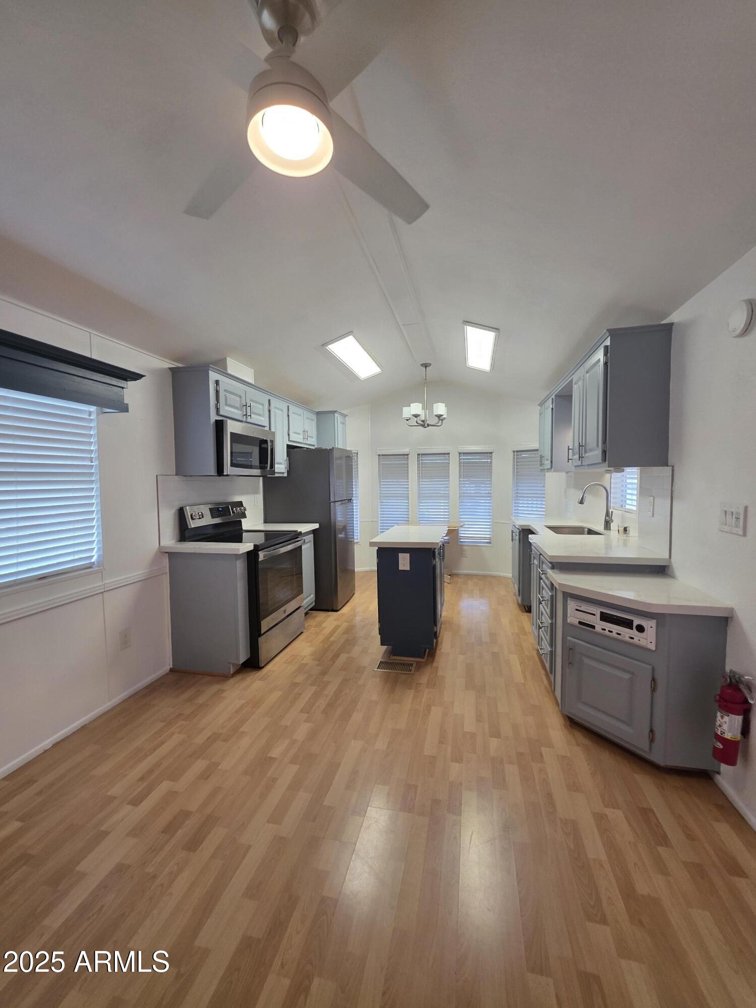 7750 East Broadway Road, Unit LOT 619 Mesa, AZ 85208 - Photo 2 of 33 a large kitchen with a stove top oven a sink a counter space and cabinets