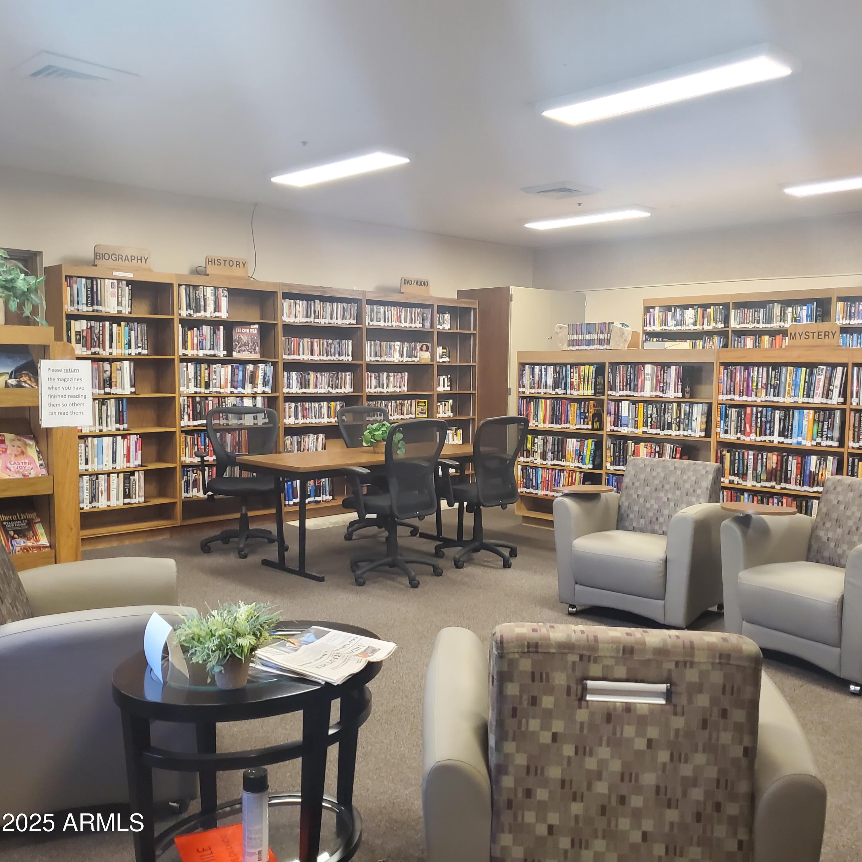 7750 East Broadway Road, Unit LOT 619 Mesa, AZ 85208 - Photo 32 of 33 a living room with furniture and a book shelf