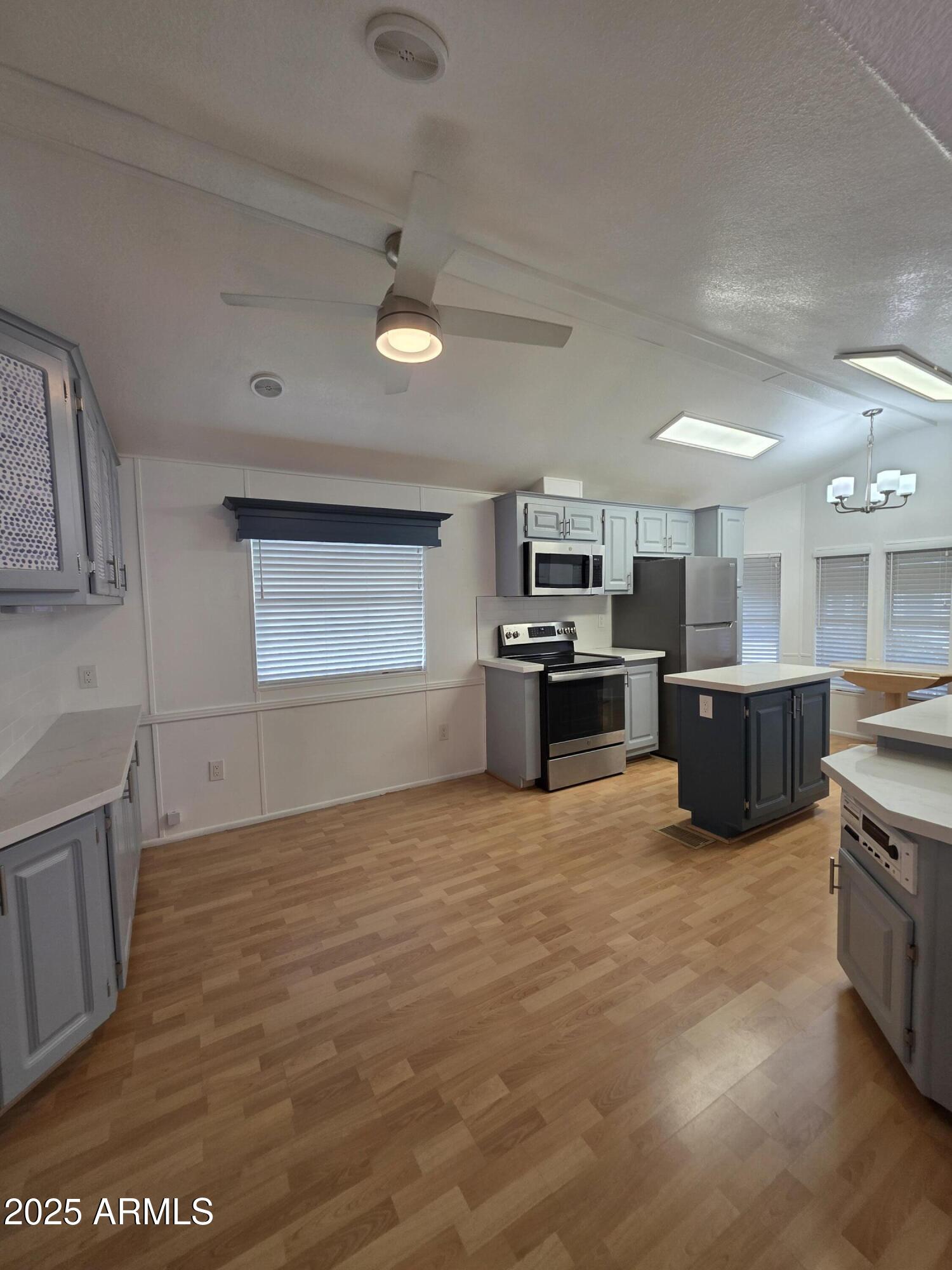 7750 East Broadway Road, Unit LOT 619 Mesa, AZ 85208 - Photo 7 of 33 a large kitchen with stainless steel appliances granite countertop a stove and a sink