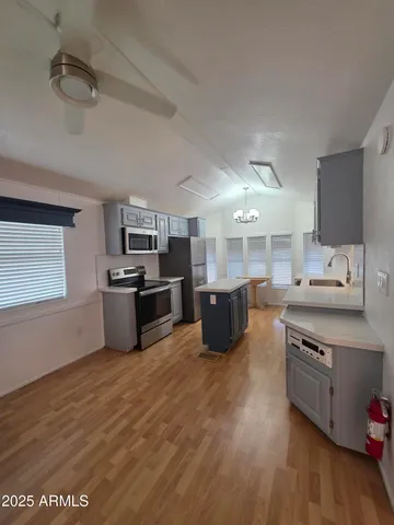 a large kitchen with stainless steel appliances wooden floors and white cabinets