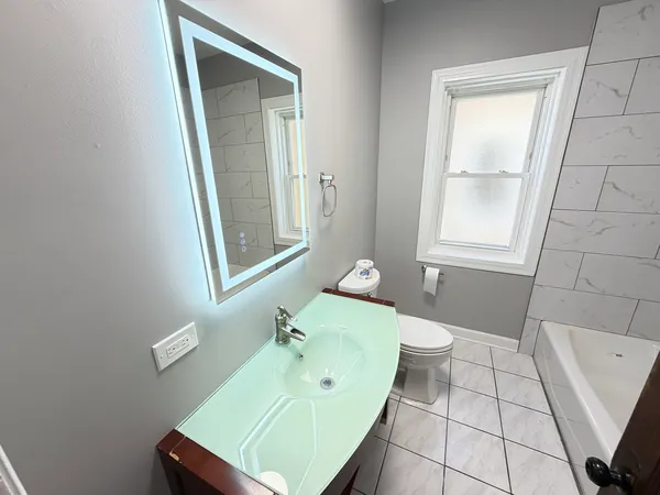 a bathroom with a sink a toilet and mirror