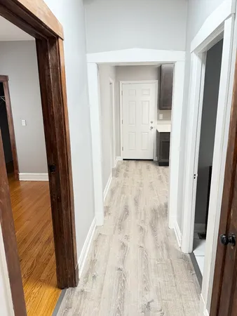 a view of a hallway with wooden floor and a living room