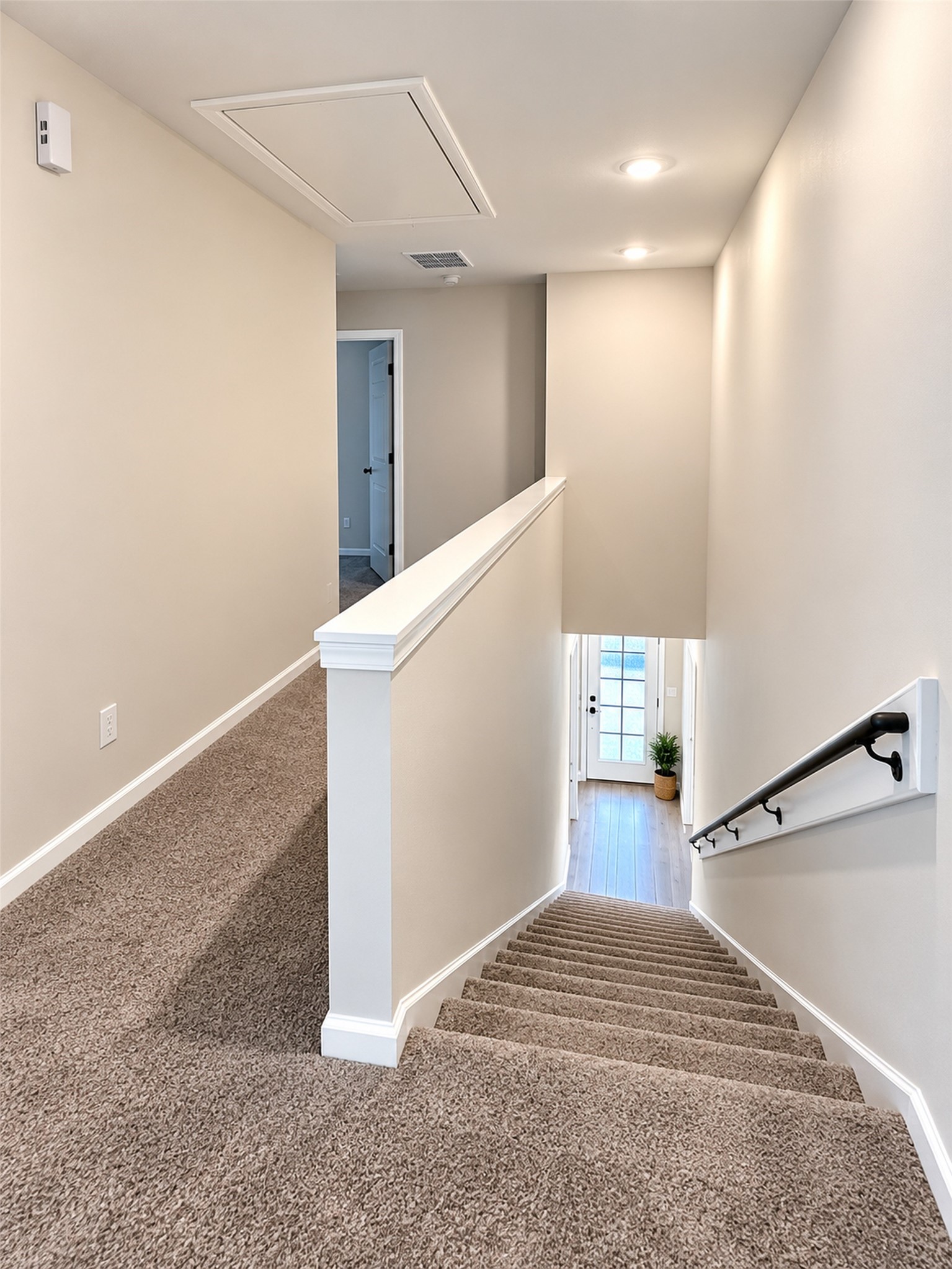 8828 Curry Road Houston, TX 77093 - Photo 6 of 15 Bright and inviting stairway with plush carpeting leads to a spacious landing and entryway, accented by soft lighting and a modern handrail.