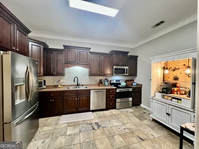 a kitchen with stainless steel appliances granite countertop a stove refrigerator sink and dishwasher