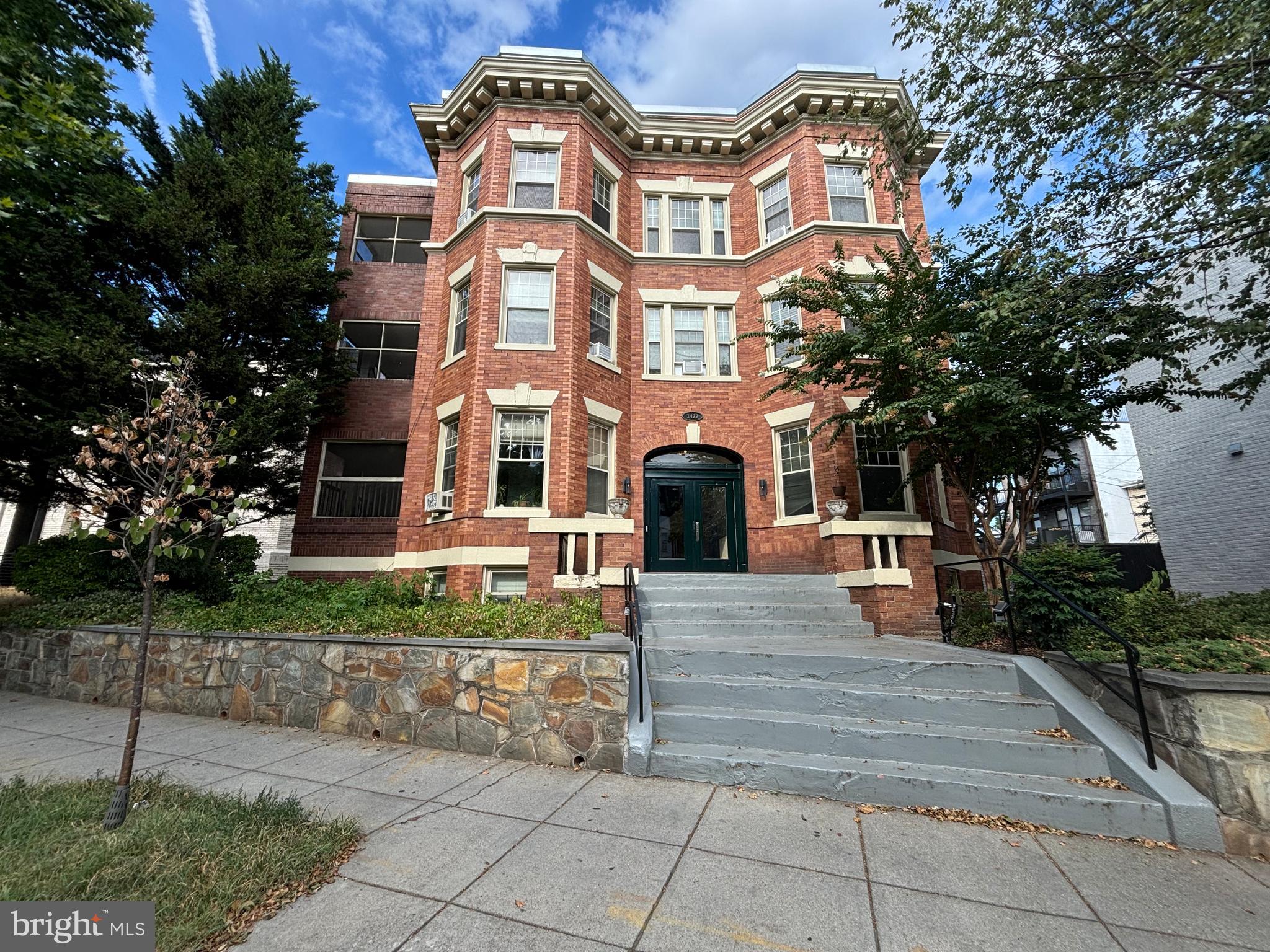 a front view of a residential apartment building with a yard
