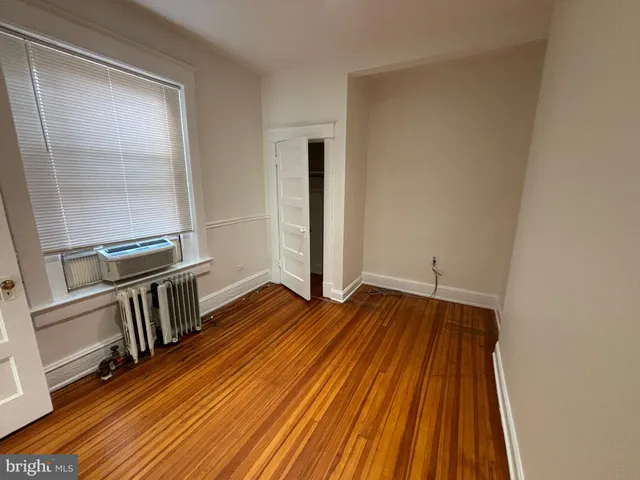 a view of a room with wooden floor and a window