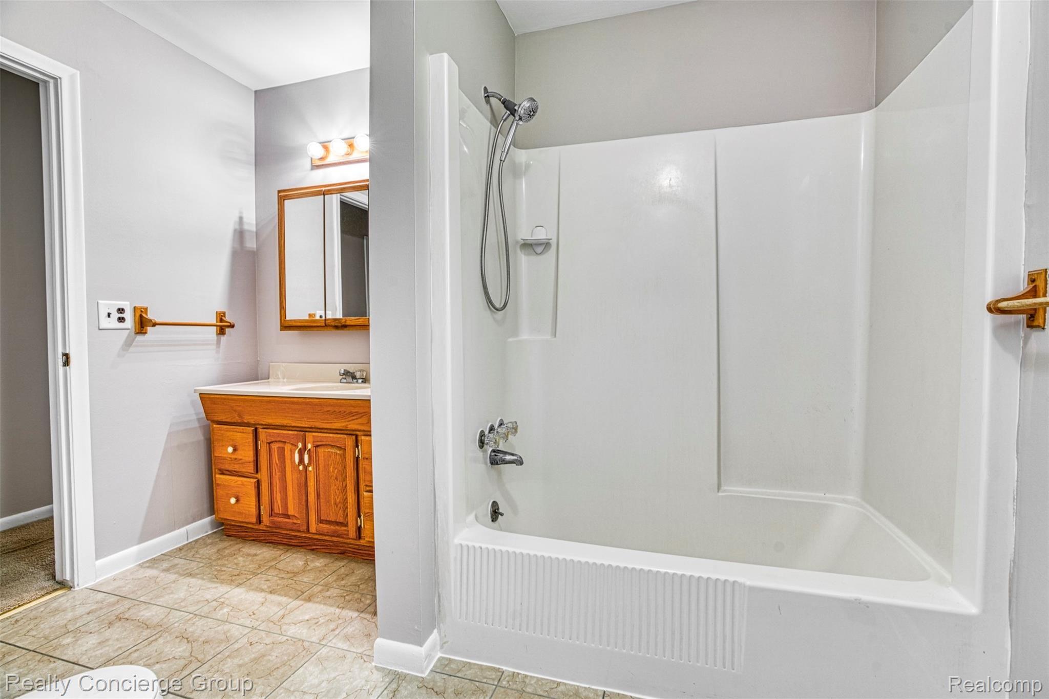 6505 Byron Road Howell, MI 48855 - Photo 9 of 20 Full bath features tub/shower and large vanity with cabinets and medicine cabinet/mirror.