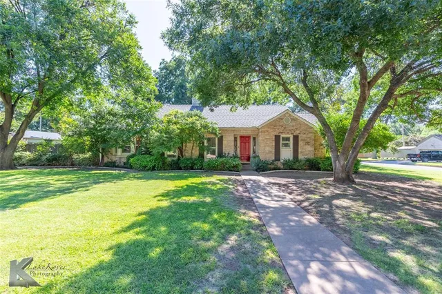 a front view of a house with yard and green space