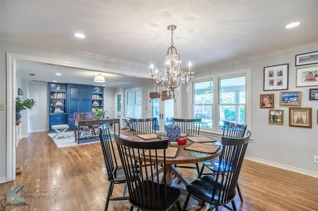 a view of a dining room with furniture a chandelier and wooden floor