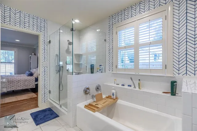 a bathroom with a tub a sink and a large mirror