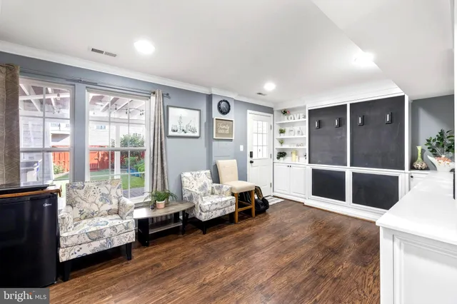 a living room with furniture stairs and a large window