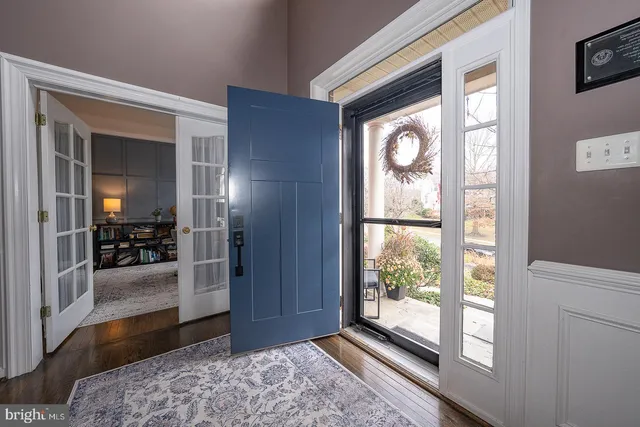 a view of an entryway with wooden floor and a livingroom