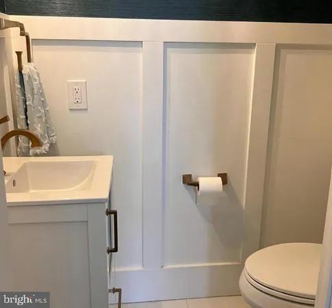 a bathroom with a sink a toilet a shower and a window