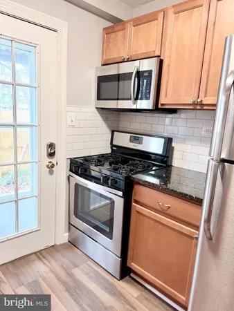 a kitchen with granite countertop a stove and a microwave