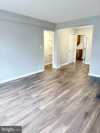 a view of empty room with wooden floor and window