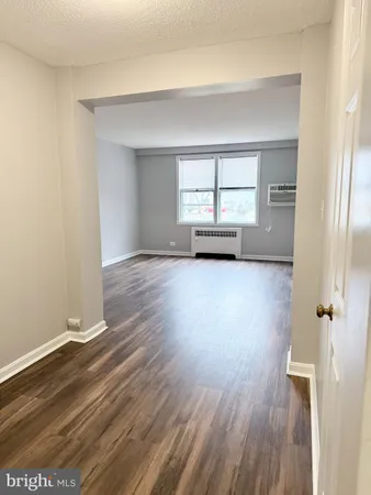 an empty room with wooden floor and a window