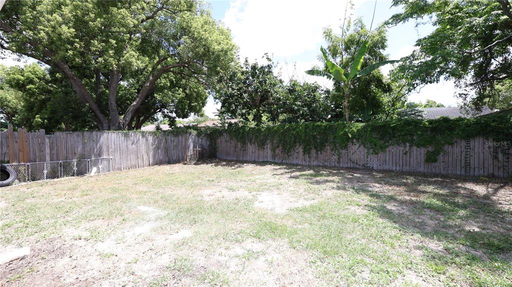 4300 Las Vegas Drive New Port Richey, FL 34653 - Photo 13 of 14 a view of a backyard with large trees and wooden fence