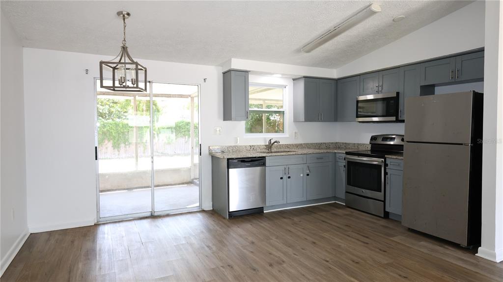 4300 Las Vegas Drive New Port Richey, FL 34653 - Photo 4 of 14 a kitchen with a refrigerator a stove a sink and a window