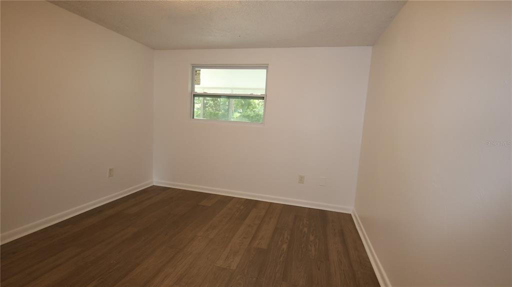 4300 Las Vegas Drive New Port Richey, FL 34653 - Photo 9 of 14 a view of an empty room with wooden floor and a window