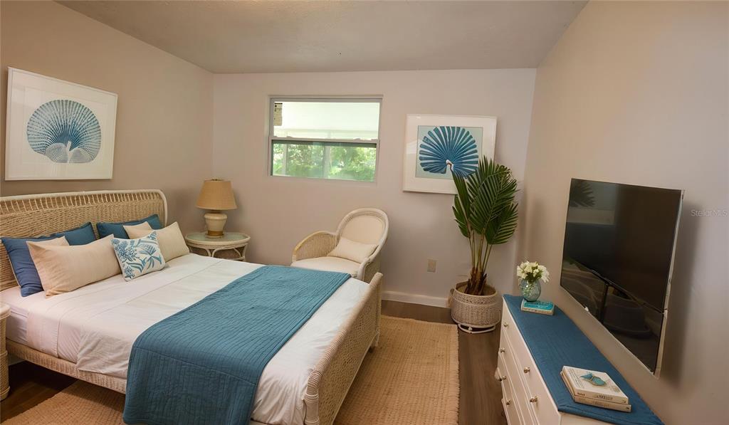 4300 Las Vegas Drive New Port Richey, FL 34653 - Photo 10 of 14 a bedroom with bed a flat tv screen and a potted plant