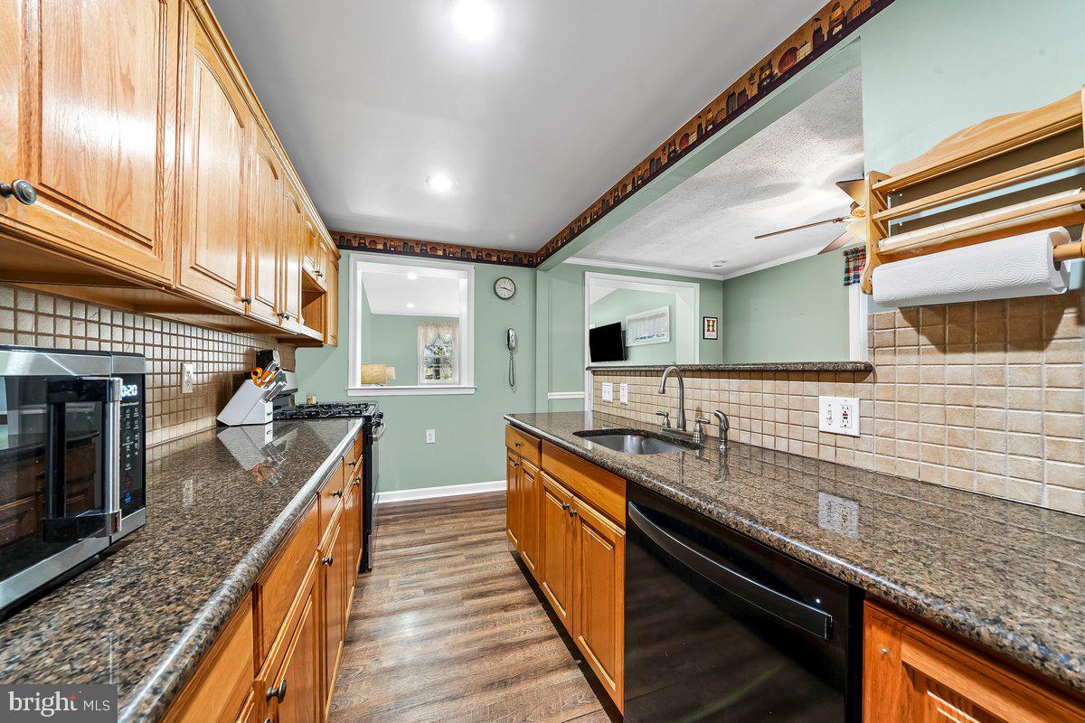 114 Lakeview Drive Ridley Park, PA 19078 - Photo 9 of 37 a large kitchen with granite countertop a sink and dishwasher a stove top oven with wooden floor