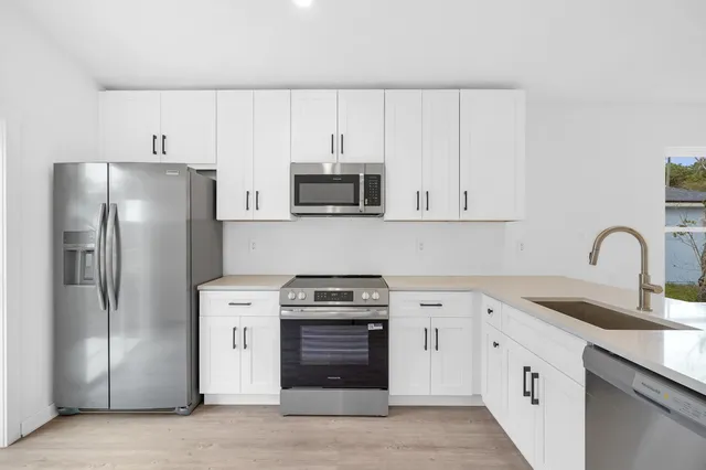 a kitchen with stainless steel appliances granite countertop a refrigerator stove and sink
