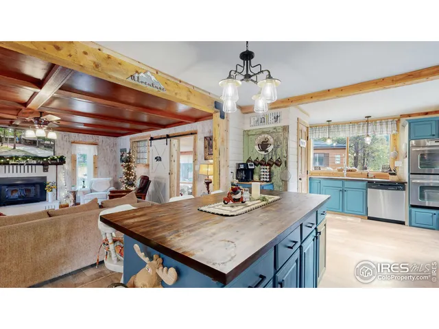 a kitchen with stainless steel appliances kitchen island granite countertop a table chairs and a wooden floor