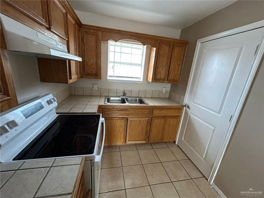 116 West 4th Street La Joya, TX 78560 - Photo 4 of 12 a kitchen with a stove sink and a microwave