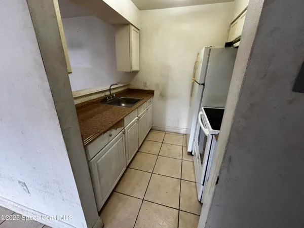 a kitchen with a sink a refrigerator and washer