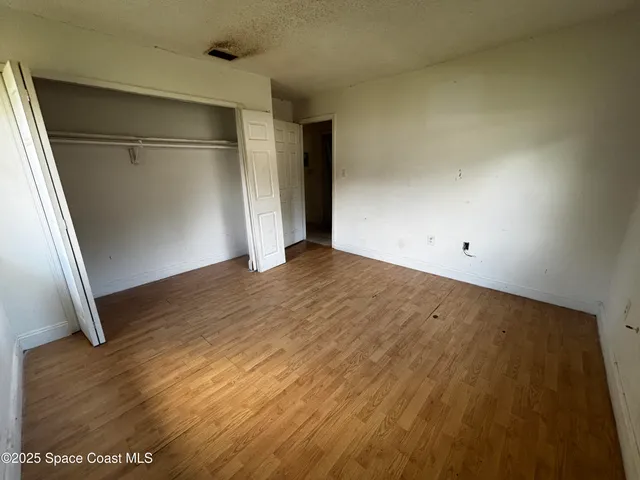 an empty room with wooden floor and entrance