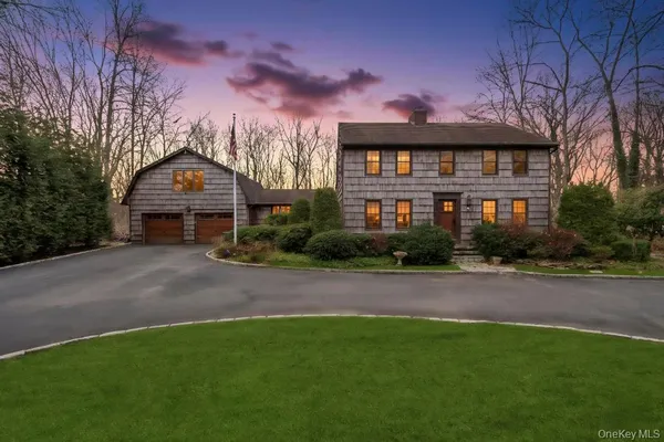 a front view of a house with yard and green space