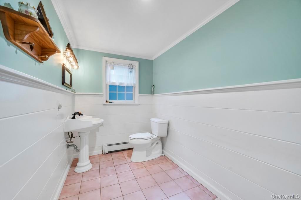 807 Union Avenue Riverhead, NY 11901 - Photo 20 of 41 a bathroom with a toilet a sink and mirror