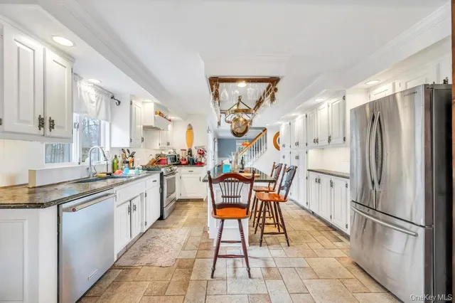 a very nice looking dining room with a large window and chandelier