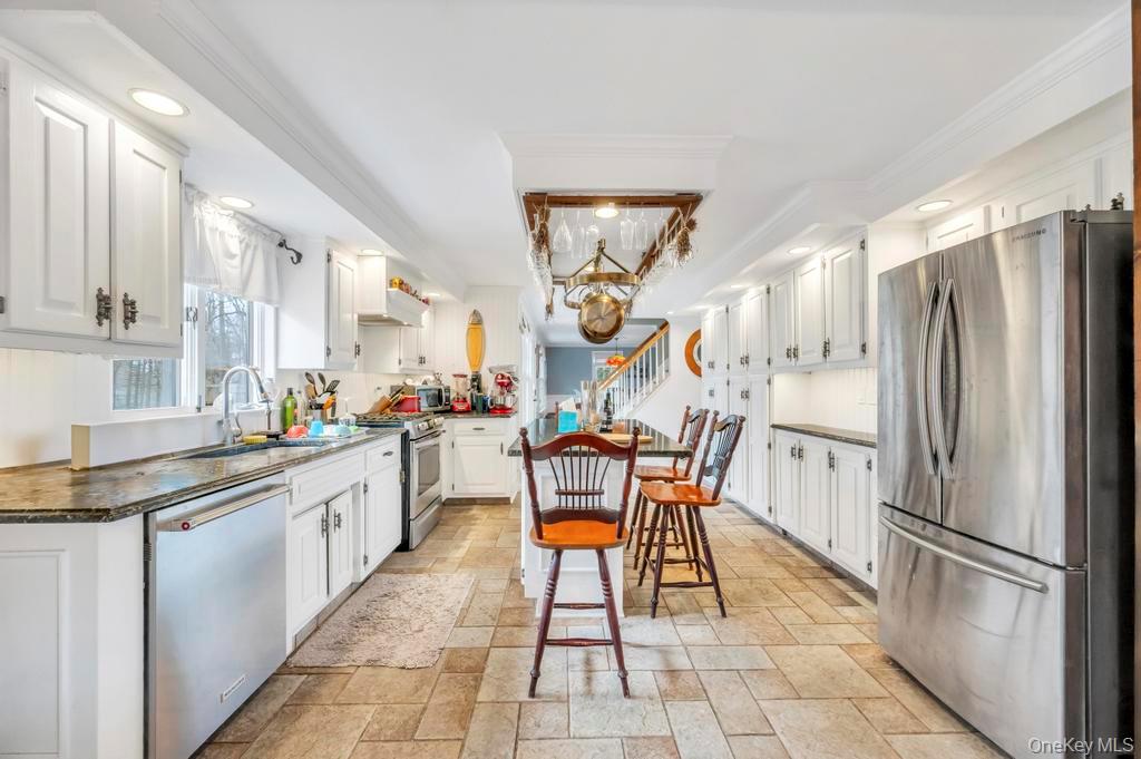 807 Union Avenue Riverhead, NY 11901 - Photo 25 of 43 a kitchen with stainless steel appliances granite countertop a sink and a refrigerator