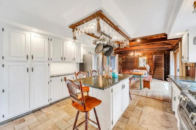 a kitchen with stainless steel appliances granite countertop a stove top oven a refrigerator a sink dishwasher and white cabinets with wooden floor