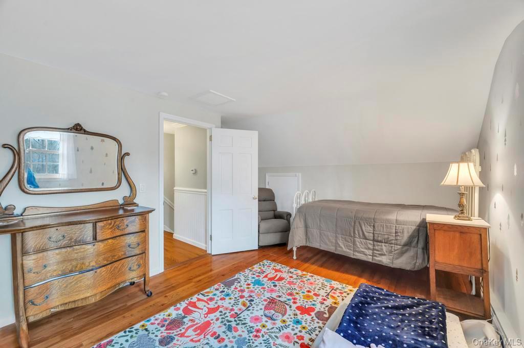 807 Union Avenue Riverhead, NY 11901 - Photo 32 of 43 a bedroom with a bed and wooden floor