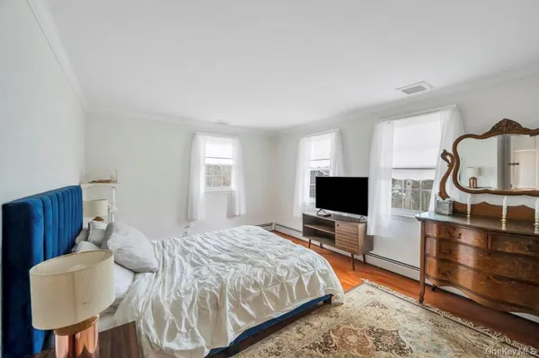 a bedroom with a bed and a flat screen tv on dresser