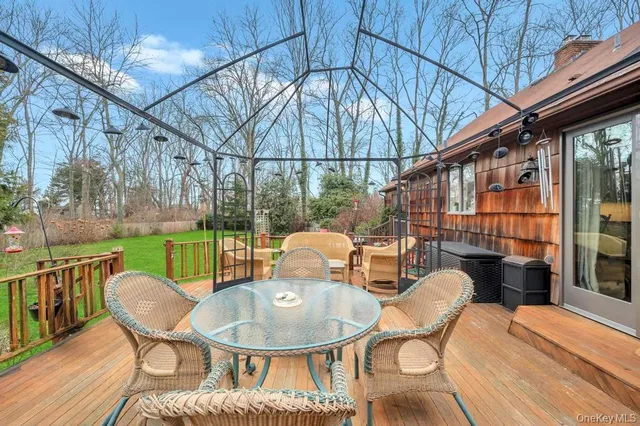 a backyard of a house with wooden floor table and chairs