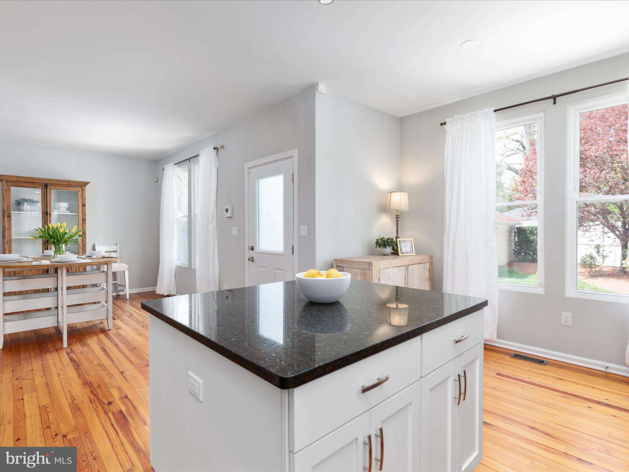 772 3rd Street Herndon, VA 20170 - Photo 13 of 52 a kitchen with granite countertop a table chairs in it and wooden floors