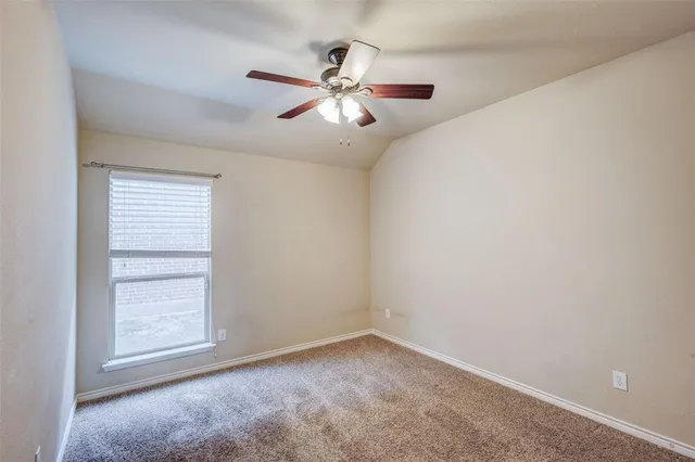 an empty room with wooden floor fireplace and windows