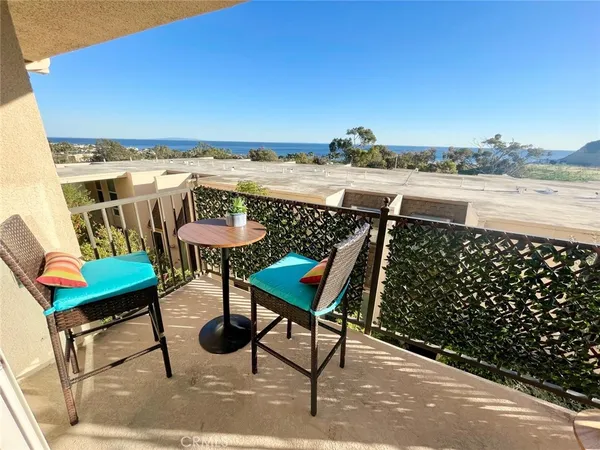 a balcony with chairs and table on the wall