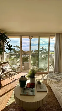 a living room with large windows and a table